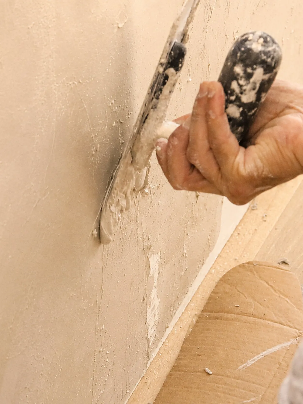 Francis applying microcement to a wall with a trowel