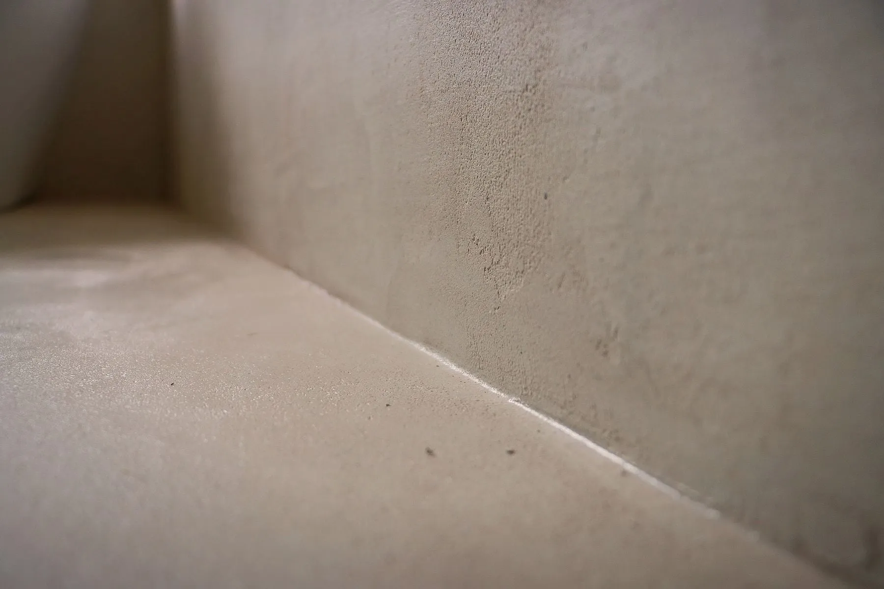 Seamless microcement floor meeting the wall, by MONC